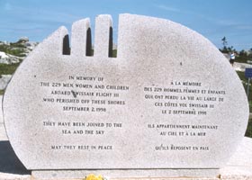 One of two large oval stone markers at Flight 111 memorial, with bilingual remembrance -- In Memory Of | The 229 Men, Women, and Children | Aboard Swissair Flight 111 | Who Perished Off These Shores | September 2, 1998 | They Have Been Joined To The | Sea and The Sky | May They Rest in Peace