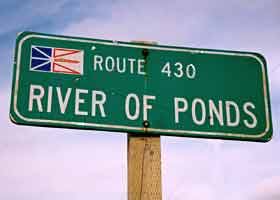Old-style River of Ponds village sign, including small provincial flag